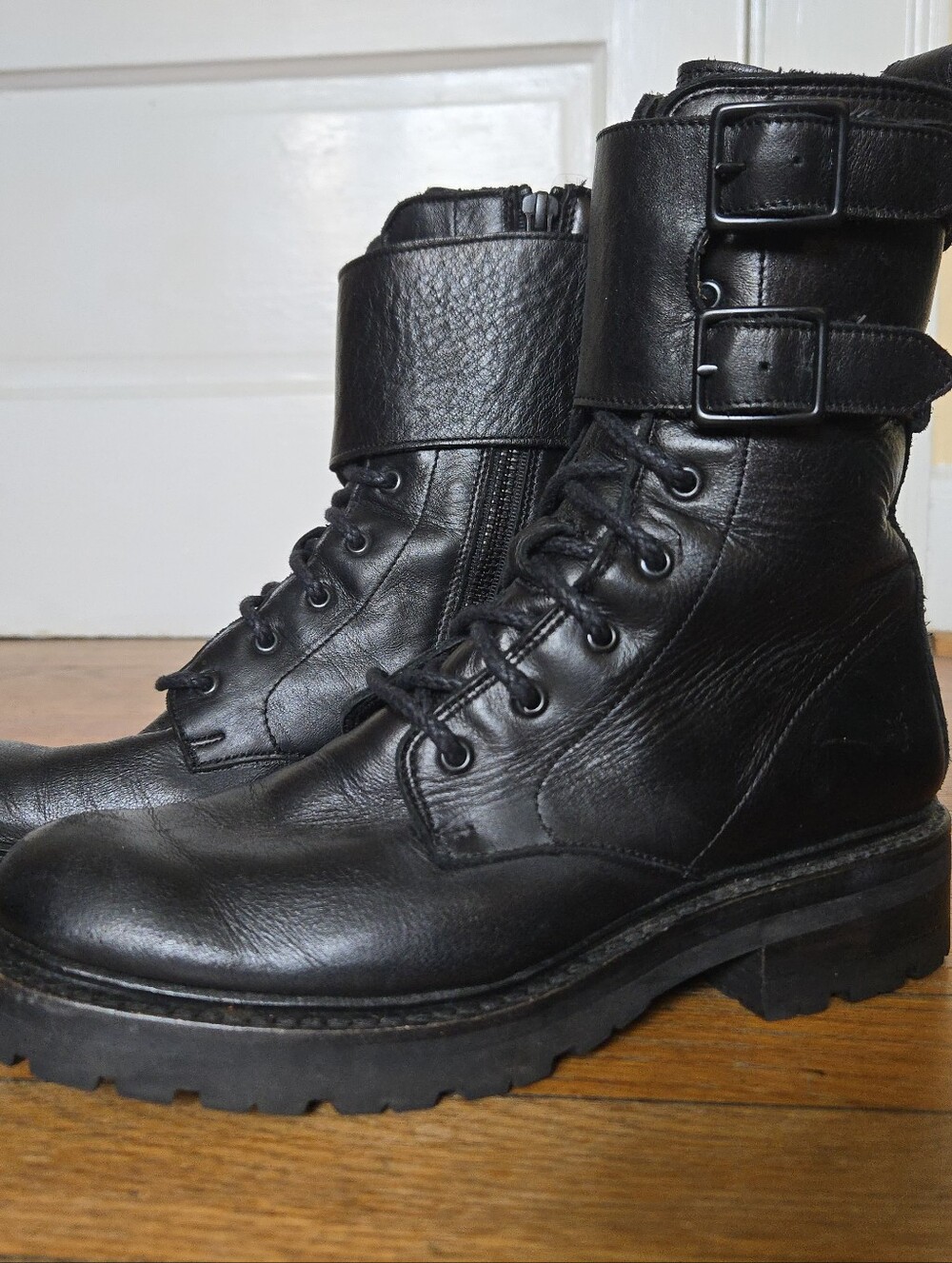 Frye black leather combat boot with 2-buckle panel, low heel, laces up, zips